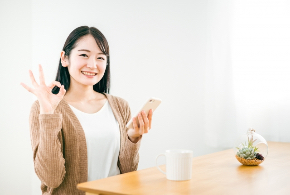 写真素材：スマホを持ってOKサインする日本人女性25325517_s.jpg